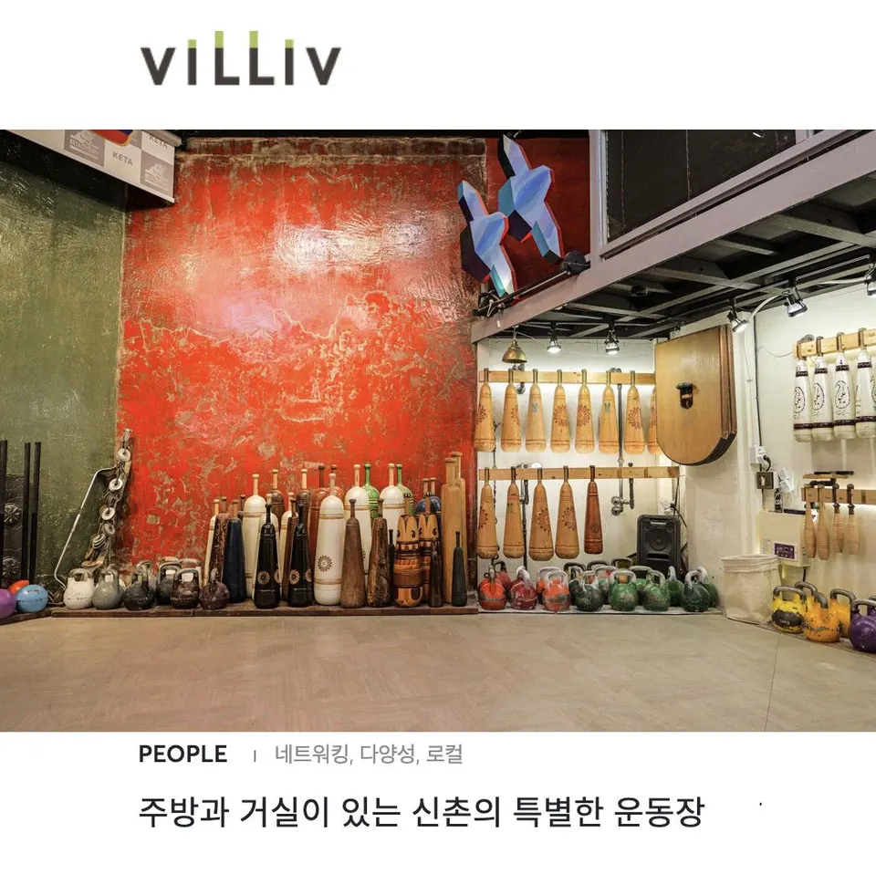 붉은 벽 아래 페르시안밀과 케틀벨이 줄지어 놓이고 벽 걸이에도 방망이가 걸린 운동장