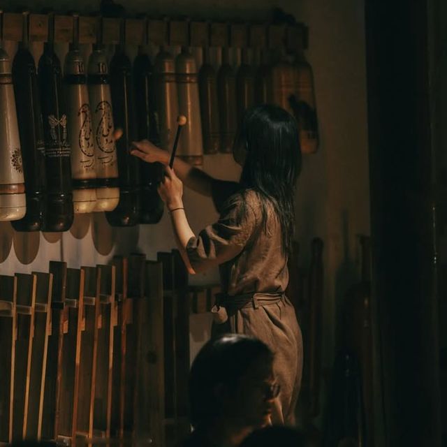 도구 벽 앞에 선 연주자.
