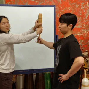 화이트보드 앞에서 방망이 다루는 법을 보여주는 장면