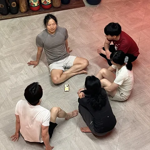 후기 작성자가 남긴 사진 — 바닥에 둘러앉아 이야기 나누는 사람들