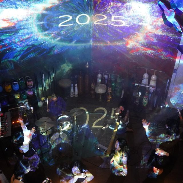 「2025」를 비춘 벽 아래 모이다.